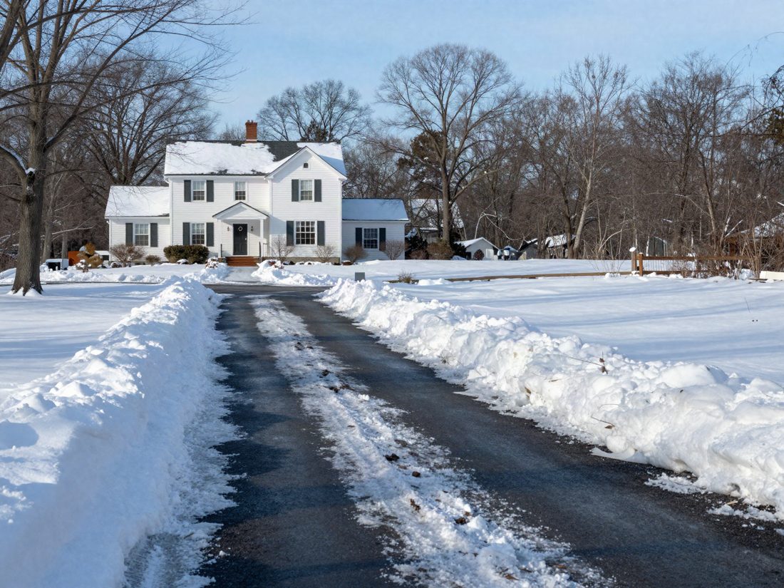 A freshly plowed driveway between clean snowbanks on a winter morning